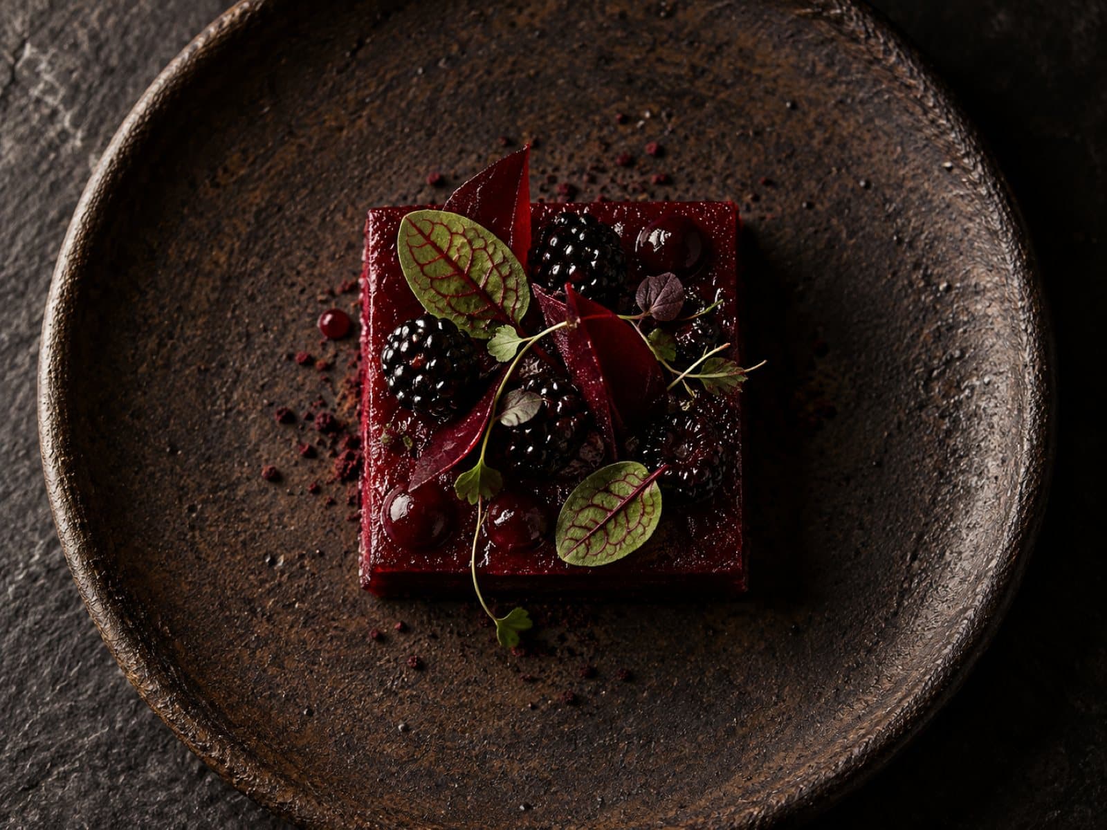Dessert van biet en braam op donker aardewerk